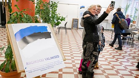 FILE: People take selfie photos after casting their vote at a polling station at the University of Tallinn, 5 March 2023