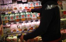 A store clerk shows plant based products at a supermarket chain in Brussels, Friday, Oct. 23, 2020.