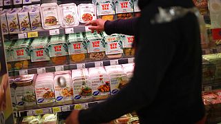 A store clerk shows plant based products at a supermarket chain in Brussels, Friday, Oct. 23, 2020.