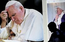 الصورة التي التقطت في 29 أبريل 2011 في روما تظهر أطفالا يمشون أمام صور عملاقة للبابا الراحل يوحنا بولس الثاني.