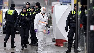A forensic expert stands beside police outside a Jehovah's Witness building in Hamburg, Germany Friday, March 10, 2023.