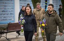 Finland's Prime Minister Sanna Marin and Ukrainian President Volodymyr Zelenskyy hold flowers at the Memorial Wall of Fallen Defenders of Ukraine in Russian-Ukrainian War, in 