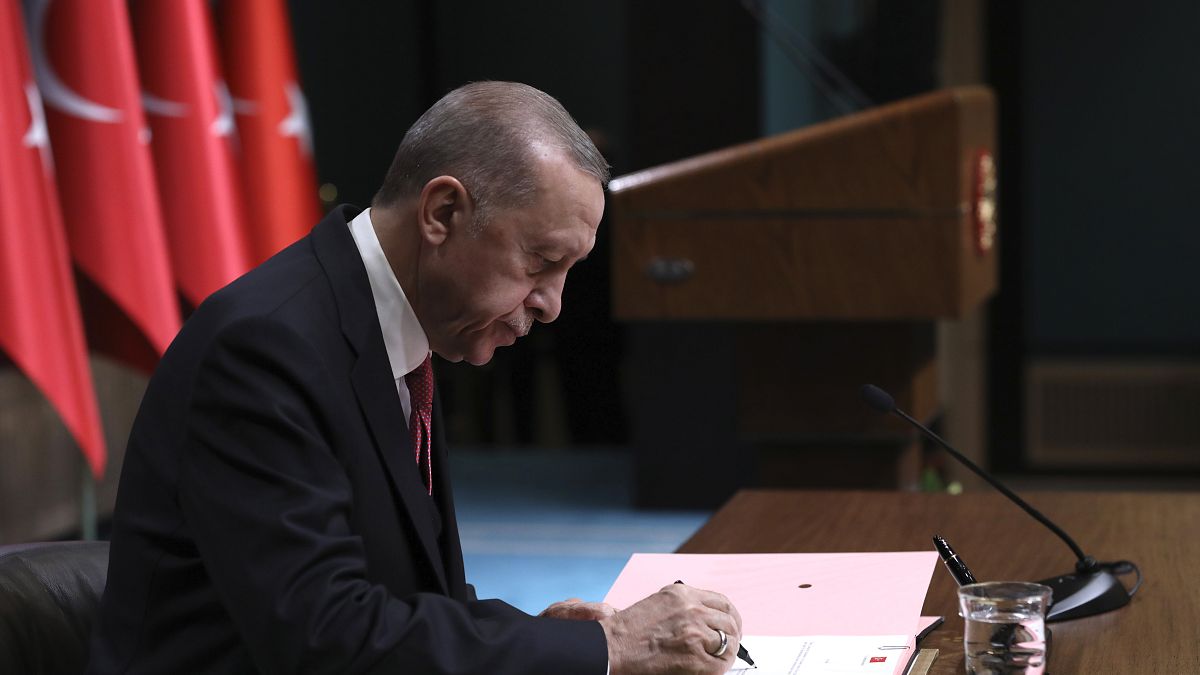 إردوغان موقعاً القرار الذي ينص على إجراء الانتخابات الرئاسية في 10 آذار-مارس 