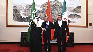 Negociador chinês, Wang Yi, ladeado pelos representantes da Arábia Saudita e Irão