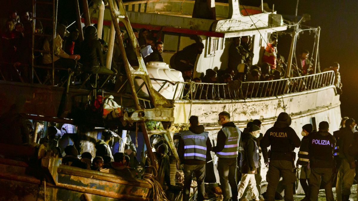 Rendőrök ellenőriznek Crotone kikötőjében 2023. március 11-én egy kimentett csempészhajót, amely 500 illegális bevándorló zsúfolódott össze
