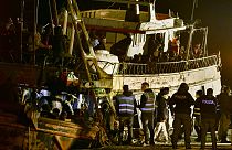 Rendőrök ellenőriznek Crotone kikötőjében 2023. március 11-én egy kimentett csempészhajót, amely 500 illegális bevándorló zsúfolódott össze