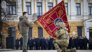 El presidente Zelenski alza una bandera con el escudo de Ucrania