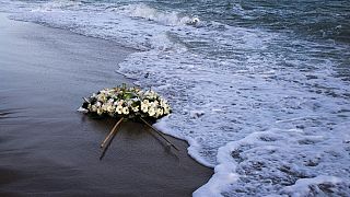 Une couronne de fleurs flotte sur la mer Méditerranée, lancée par à la fin d'une marche de protestation sur la plage du naufrage le 11 mars 2023