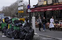 Eine Straße in Paris: Berge von Müllsäcken und überfüllte Mülleimer