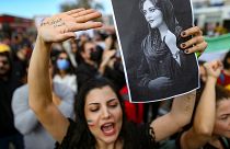 Una mujer sostiene un dibujo de la iraní Mahsa Amini mientras grita consignas durante una protesta contra su muerte, en Estambul, Turquía, el domingo 2 de octubre de 2022.