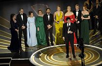 Daniel Roher (középen) kezében az Oscar-díjjal, mögötte Navalnij családja és a dokumentumfilm további alkotói