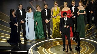 Daniel Roher (középen) kezében az Oscar-díjjal, mögötte Navalnij családja és a dokumentumfilm további alkotói