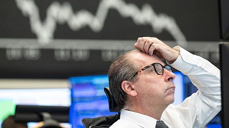 A stock exchange trader observes the price development at the German Stock Exchange in Frankfurt, Germany, Monday, March 13, 2023.