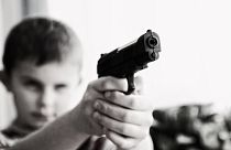 طفل بيده مسدس