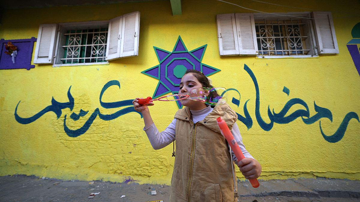 طفلة فلسطينية أمام أحد الجدران الملونة بالبلدة القديمة في غزة 