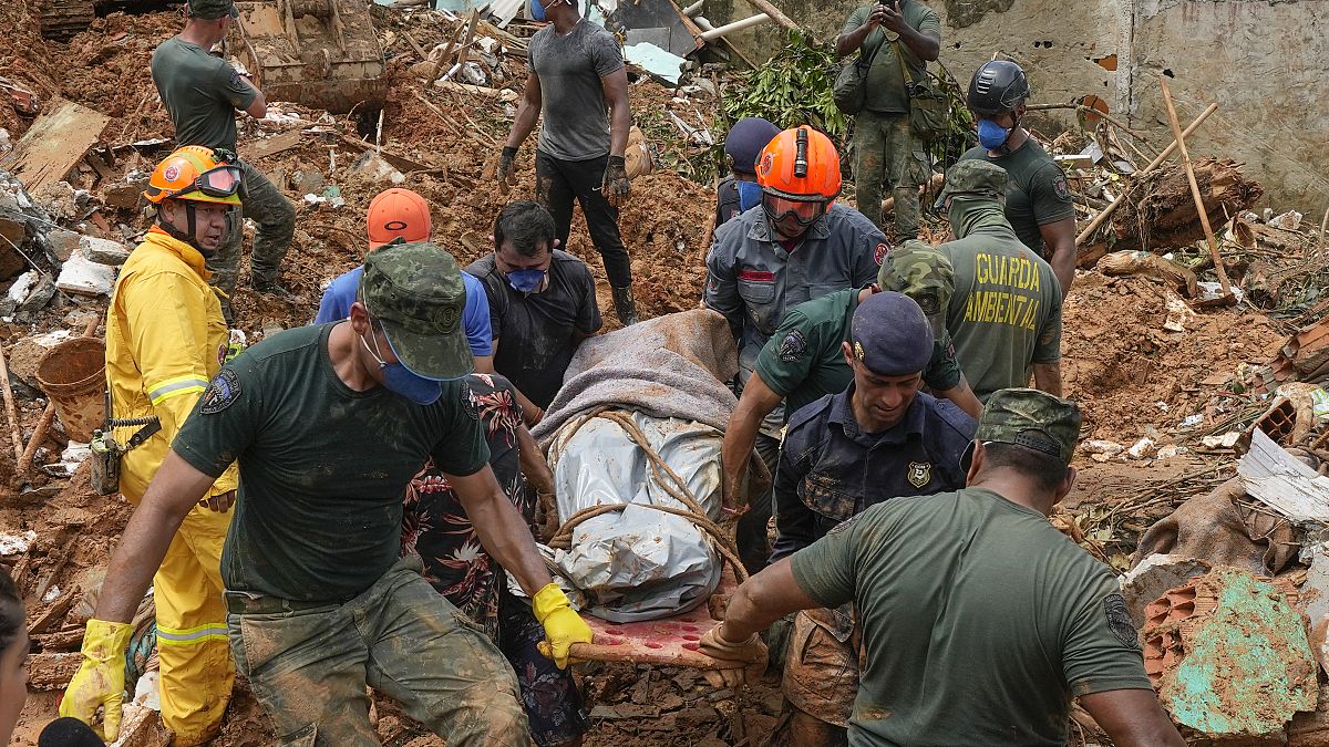Rescue workers and volunteers carry the body of a landslide victim near Barra do Sahy beach after heavy rains in the coastal city of Sao Sebastiao, Brazil