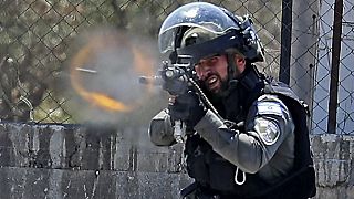 Membro das forças de segurança disparando projétil em Israel