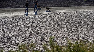 أشخاص يسرون بمحاذاة أرض متشققة جراء الجفاف عند بحيرة ميد الوطنية للاستجمام ، نيفادا، الولايات المتحدة، 27 يناير 2023.