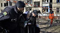 Polícia ucraniano auxilia uma mulher ferida após o bombardamento russo em Kramatorsk