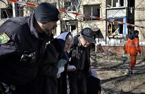 Polícia ucraniano auxilia uma mulher ferida após o bombardamento russo em Kramatorsk