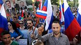  Syrians holding photos of Syrian President Bashar Assad and Russian flags, during a protest to thank Moscow for its intervention in Syria, 2015.