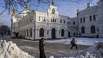 A monk and a woman walk inside the Pechersk Lavra monastic complex in Kyiv, Ukraine, on Dec 1