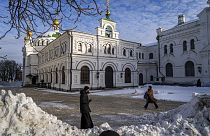 A monk and a woman walk inside the Pechersk Lavra monastic complex in Kyiv, Ukraine, on Dec 1