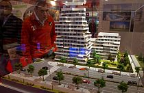 A man looks at a model of a housing estate during an estate agents housing fair in Madrid Friday April 20, 2012.