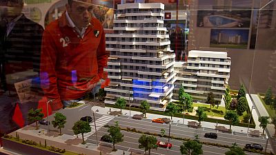 A man looks at a model of a housing estate during an estate agents housing fair in Madrid Friday April 20, 2012.