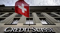 Swiss flag flies over a sign of Swiss bank Credit Suisse in Bern on Marach 13, 2023