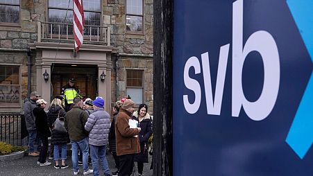 Customers line up outside a Silicon Valley Bank branch in Wellesley, Massachusetts, USA, Monday, March 13, 2023.