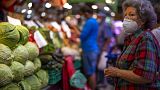 A customer wearing a face mask waits to buy vegetables at the Maravillas market in Madrid.