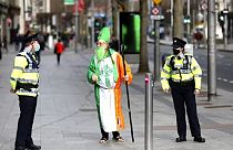 Un hombre disfrazado de San Patricio habla con la policía