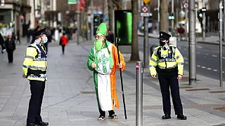Un hombre disfrazado de San Patricio habla con la policía