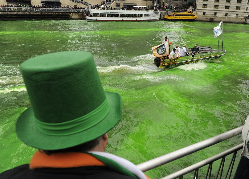Зритель наблюдает, как река Чикаго окрашивается в зеленый цвет перед парадом в честь Дня Святого Патрика в Чикаго, суббота, 16 марта 2013 года.