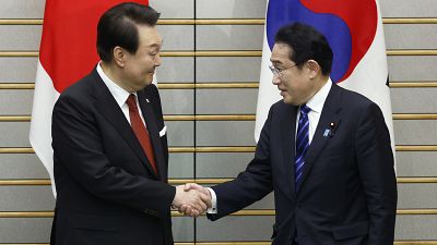 South Korean President Yoon Suk Yeol and Japanese Prime Minister Fumio Kishida shake hands