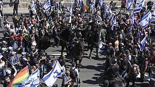 Израильские конные полицейские разгоняют демонстрантов, блокирующих шоссе во время акции протеста против планов правительства Нетаньяху