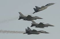 Two Polish Air Force Russian made Mig 29's fly above and below two Polish Air Force U.S. made F-16's fighter jets during the Air Show in Radom, Poland, Saturday, Aug. 27, 2011