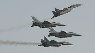 Two Polish Air Force Russian made Mig 29's fly above and below two Polish Air Force U.S. made F-16's fighter jets during the Air Show in Radom, Poland, Saturday, Aug. 27, 2011