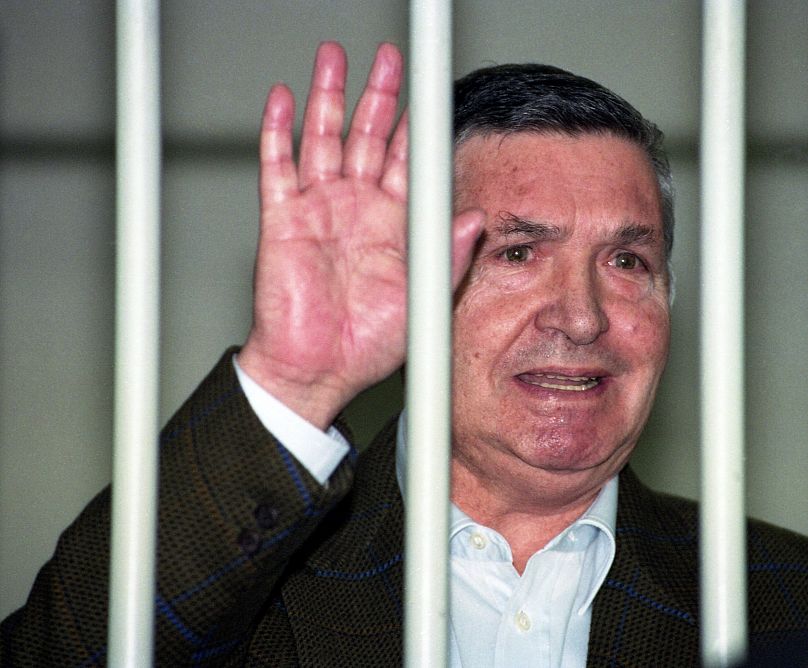في 29 أبريل / نيسان الفاتور توتو ريينا، رئيس زعماء المافيا المشهور يلوح من خلف القضبان في محكمة روما أثناء محاكمته