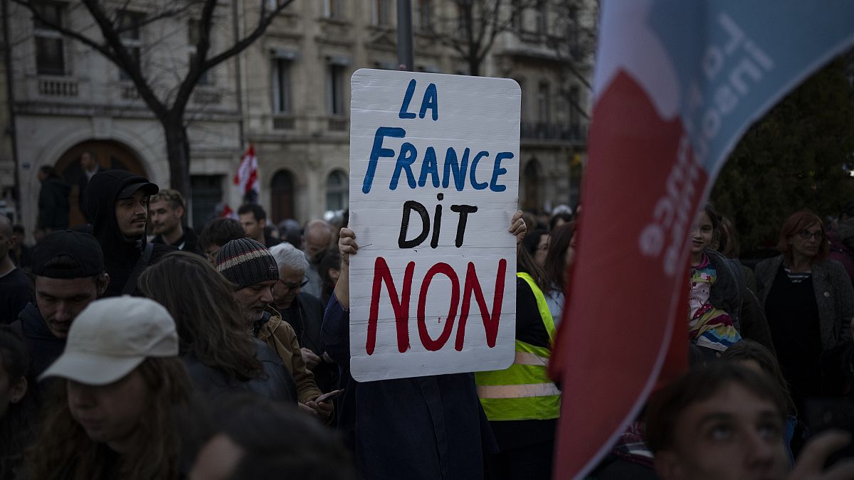 A woman holds a sign reading "France says no" during a demonstration in Marseille. 16 March, 2023
