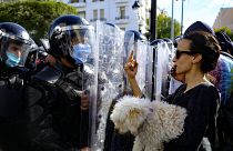 تونسية تحمل كلبا تشير بإصبعها الأوسط لرجال الشرطة أمام وزارة الداخلية بالعاصمة تونس 30/01/2021