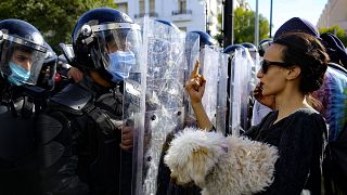 تونسية تحمل كلبا تشير بإصبعها الأوسط لرجال الشرطة أمام وزارة الداخلية بالعاصمة تونس 30/01/2021