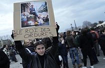 "König des Abfalls" steht auf dem Plakat dieser Demonstrantin in Paris