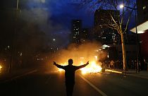 Ein Demonstrant steht vor brennenden Mülltonnen während einer Demonstration in Paris