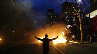 Ein Demonstrant steht vor brennenden Mülltonnen während einer Demonstration in Paris