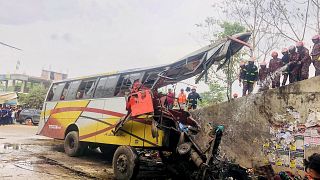 رجال الإطفاء يتفحصون الحافلة التي تحطمت في منطقة ماداربور في ينغلادش 