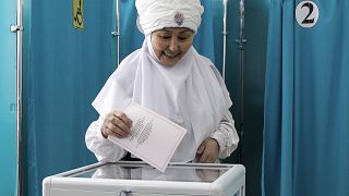 Eine Frau in kasachischer Nationaltracht gibt am Sonntag, den 19. März 2023, in einem Wahllokal in der kasachischen Hauptstadt Astana ihre Stimme ab