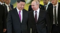 FILE - Xi Jinping and Vladimir Putin walking side by side.