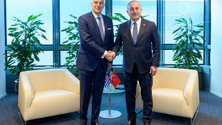 Ο Έλληνας υπουργός Εξωτερικών, Νίκος Δένδιας ανταλλάσσει χειραψία με τον Τούρκο ομόλογό του Μεβλούτ Τσαβούσογλου κατά τη διάρκεια της συνάντησής τους στις Βρυξέλλες